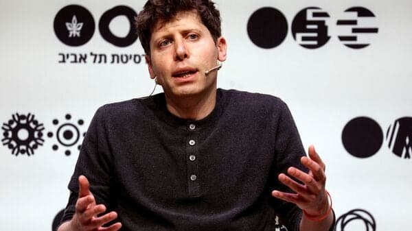 "Sam Altman speaking at a tech event, with Meta and OpenAI logos in the background, symbolizing AI talent competition."
